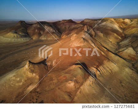 Curved crest of Aktumsik Cape reveals geological bands above vast desert plain 127275681