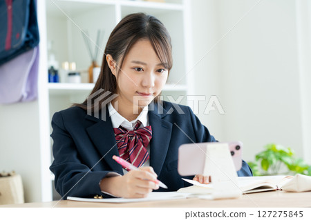 High school girl studying on smartphone High school girl studying on smartphone 127275845