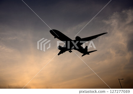Airplane in the evening sky 127277089