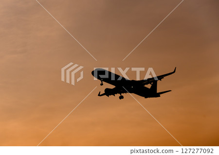 Airplane in the evening sky 127277092