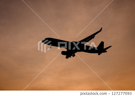 Airplane in the evening sky 127277093