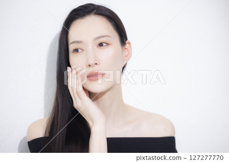 A woman wearing a black off-the-shoulder 127277770