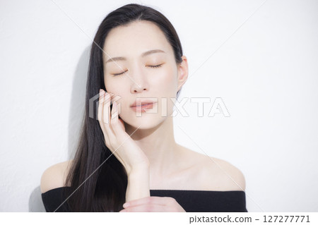 A woman wearing a black off-the-shoulder A woman wearing a black off-the-shoulder 127277771