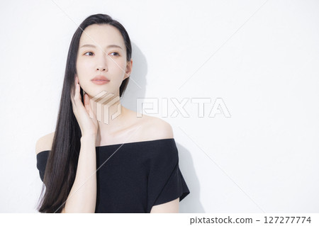 A woman wearing a black off-the-shoulder 127277774