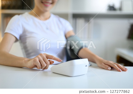 Closeup woman check up low blood pressure with digital pressure monitor, Hypotension problem Closeup woman check up low blood pressure with digital pressure monitor, Hypotension problem 127277862