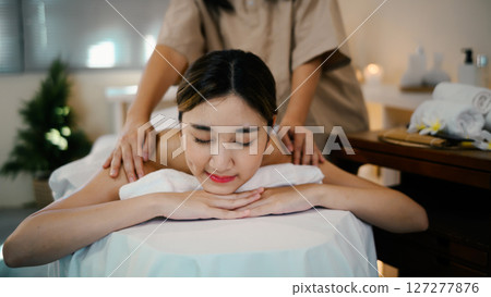 relaxed woman enjoying professional wellness massage in spa 127277876