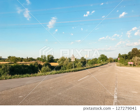 View of a highway with a fork in the road on a sunny summer day View of a highway with a fork in the road on a sunny summer day 127279041