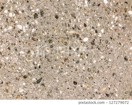 A grey and white stone surface with many small rocks scattered across it 127279072
