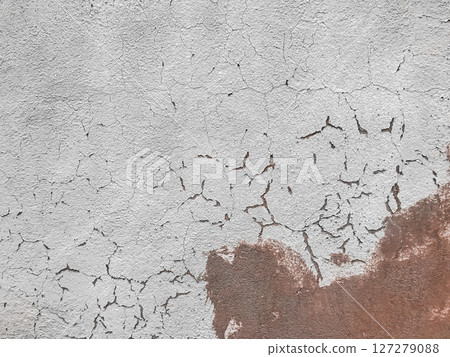 A wall with a lot of cracks and holes 127279088