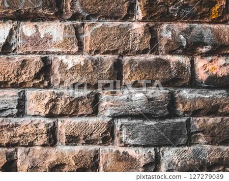 A brick wall with a few white marks on it 127279089