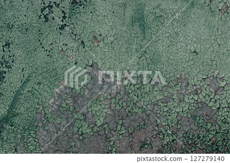 The wall is covered in green paint and has a lot of cracks and holes The wall is covered in green paint and has a lot of cracks and holes 127279140