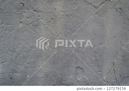 A grey wall with many scratches and marks 127279156