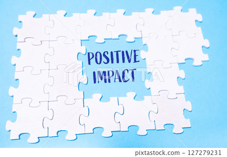Jigsaw puzzle with the word positive impact written in blue 127279231
