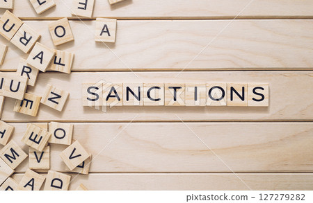 A wooden board with a jumble of letters scattered across it 127279282