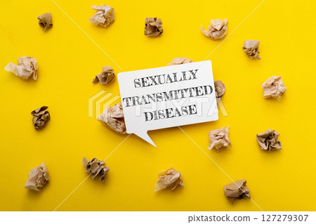 A yellow background with a white sign that says Sexually Transmitted Disease 127279307