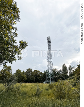 Tall tower is in the middle of a field 127279358