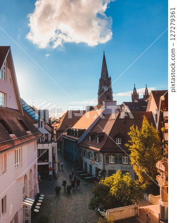 City street with a large building in the background 127279361