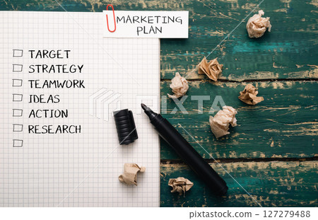 Black marker sits on a piece of paper with a marketing plan written on it Black marker sits on a piece of paper with a marketing plan written on it 127279488