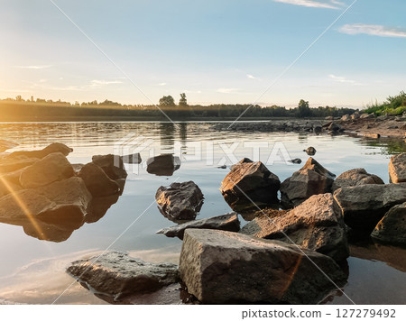 Rocky shoreline with a body of water in the background Rocky shoreline with a body of water in the background 127279492