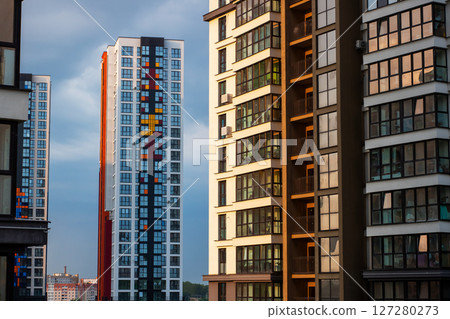 A picturesque row of tall buildings against a bright blue sky in the background 127280273