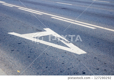 There is a white arrow that is painted on the side of the road 127280292