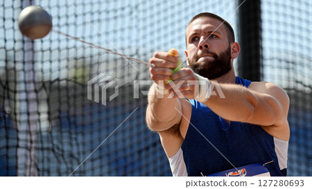 Hammer Throw Athlete Practicing Technique During a Sunny Day at a Training Facility 127280693