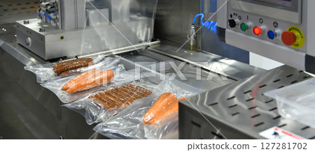 High-performance machines are wrapping food products food in production lines on conveyor belts, food production industry High-performance machines are wrapping food products food in production lines on conveyor belts, food production industry 127281702