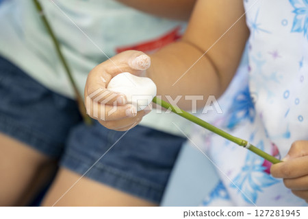 Children making bamboo rolls 127281945