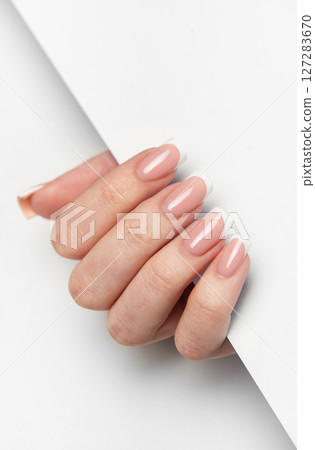 Woman hand showing french manicure on white background 127283670