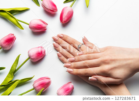 Woman showing french manicure near pink tulips on white background Woman showing french manicure near pink tulips on white background 127283671