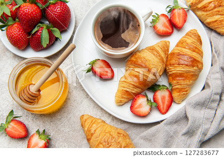 Delicious breakfast with coffee, croissants, strawberries, and honey 127283677