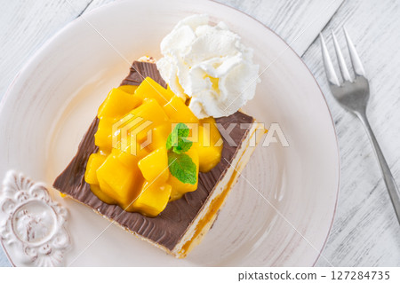 Square Mango Cheesecake With Chocolate Glaze, Fresh Cubes, and Whipped Cream Square Mango Cheesecake With Chocolate Glaze, Fresh Cubes, and Whipped Cream 127284735