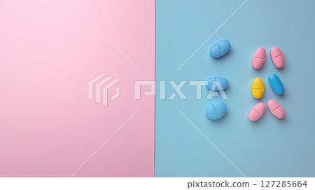 Split background with blank pink side and pastel-colored pills on blue side for health and wellness concepts 127285664