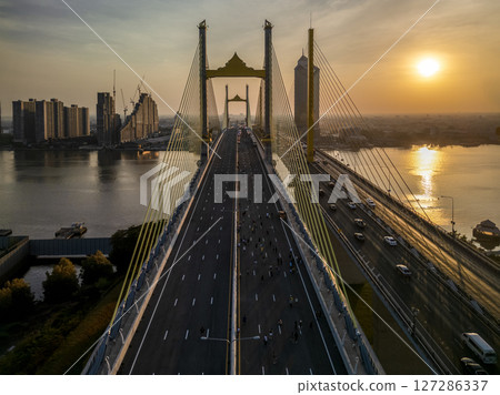 Thotsamarachan Bridge (Rama IX Bridge) crossing Chao phraya river. Beautiful city of Bangkok during sunset time. 127286337