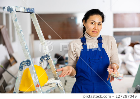 Frustrated woman builder is unhappy with earned money Frustrated woman builder is unhappy with earned money 127287049