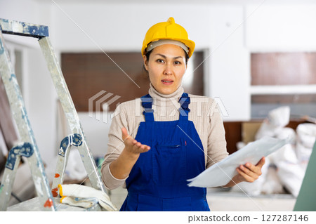 Frustrated woman builder checking project documentation 127287146