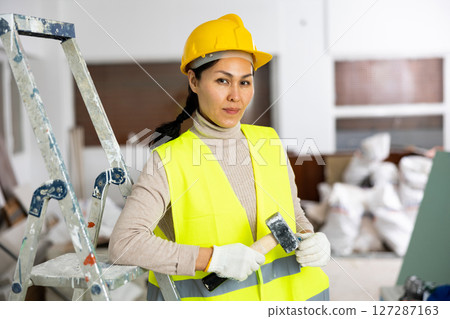 Portrait of Asian woman engineer holding hammer 127287163