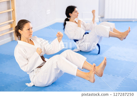 Two women training their abs in studio 127287250