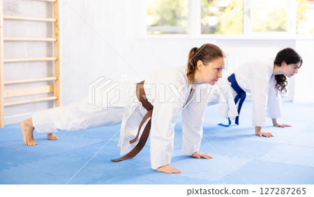 Two women training their abs in studio 127287265