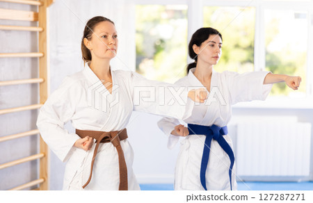 Two women training karate techniques in studio 127287271