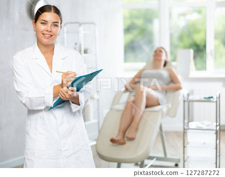 Young female doctor making notes in medical room Young female doctor making notes in medical room 127287272