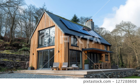 Modern Wooden Cabin with Solar Panels and Deck in a Wooded Setting 127288608
