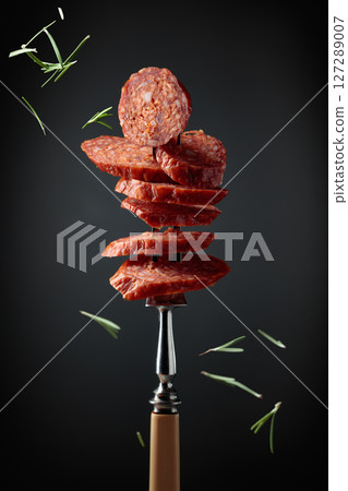 Sliced chorizo on a fork. 127289007