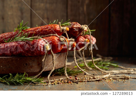 Smoked and dry cured sausages on a rustic background. Smoked and dry cured sausages on a rustic background. 127289013