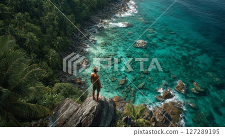 Man on Tropical Cliff Overlooking Turquoise Ocean 127289195