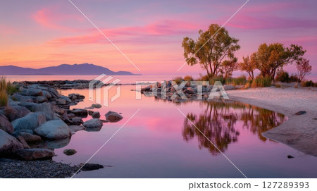 Pink and Purple Sunset Over Calm Lake with Tree Reflections 127289393