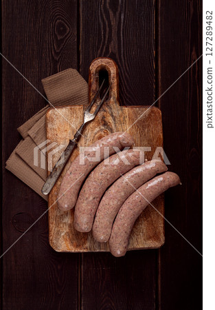 raw sausages in English with bacon, for grilling, on a cutting board, top view, no people, 127289482