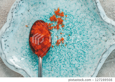 a spoon with orange flying fish caviar, Tobiko, on a light blue plate, caviar for rolls and sushi, close-up, a spoon with orange flying fish caviar, Tobiko, on a light blue plate, caviar for rolls and sushi, close-up, 127289508