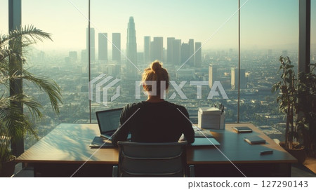 Woman Working at Desk with City View 127290143