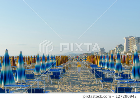 Parasols and sunbeds in Rimini resort beach Parasols and sunbeds in Rimini resort beach 127290942